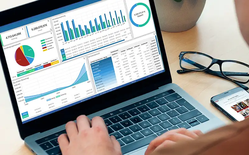 Zwei Männer in einem Büro diskutieren etwas auf einem Tablet neben einem Farbmultifunktionsdrucker der Xerox® AltaLink® C8200-Serie